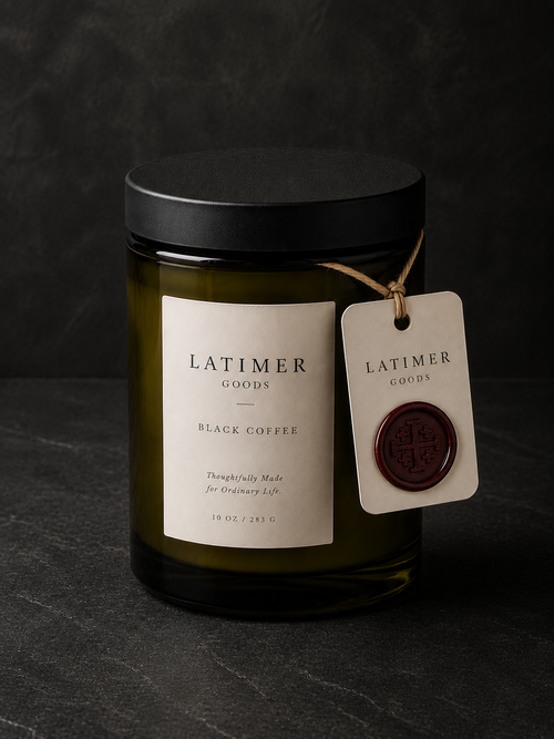 Latimer Goods Black Coffee Candle in deep olive glass jar with ivory label and oxblood wax seal tag on dark background
