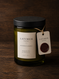 Latimer Goods Bourbon Barrel Candle in olive green glass jar with ivory label and oxblood wax seal tag
