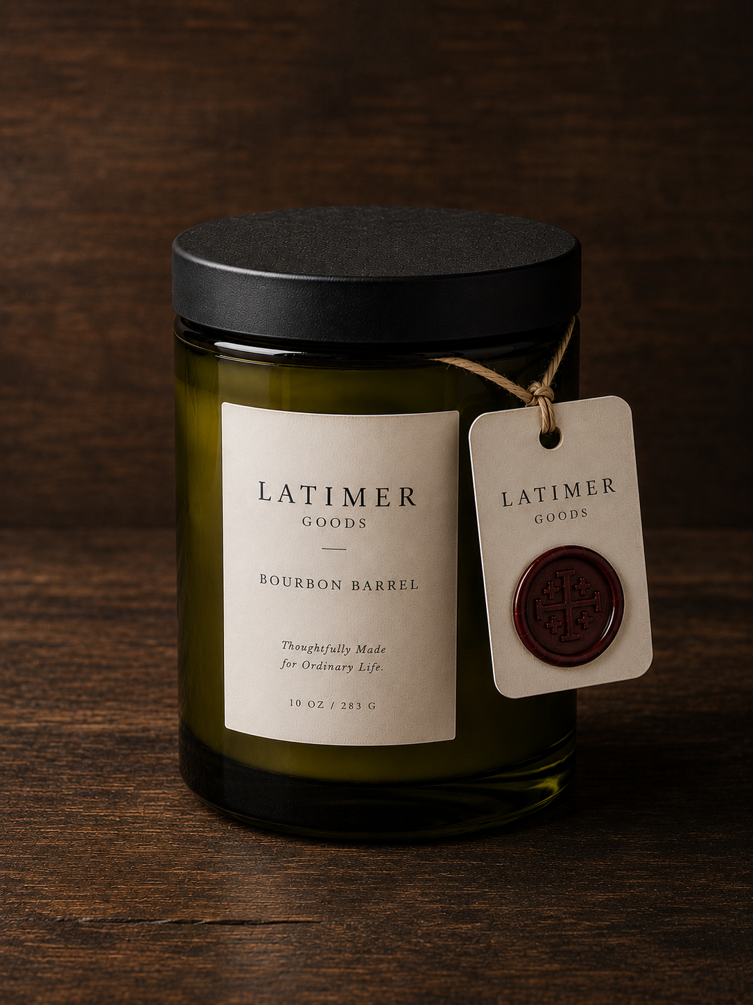 Latimer Goods Bourbon Barrel Candle in olive green glass jar with ivory label and oxblood wax seal tag