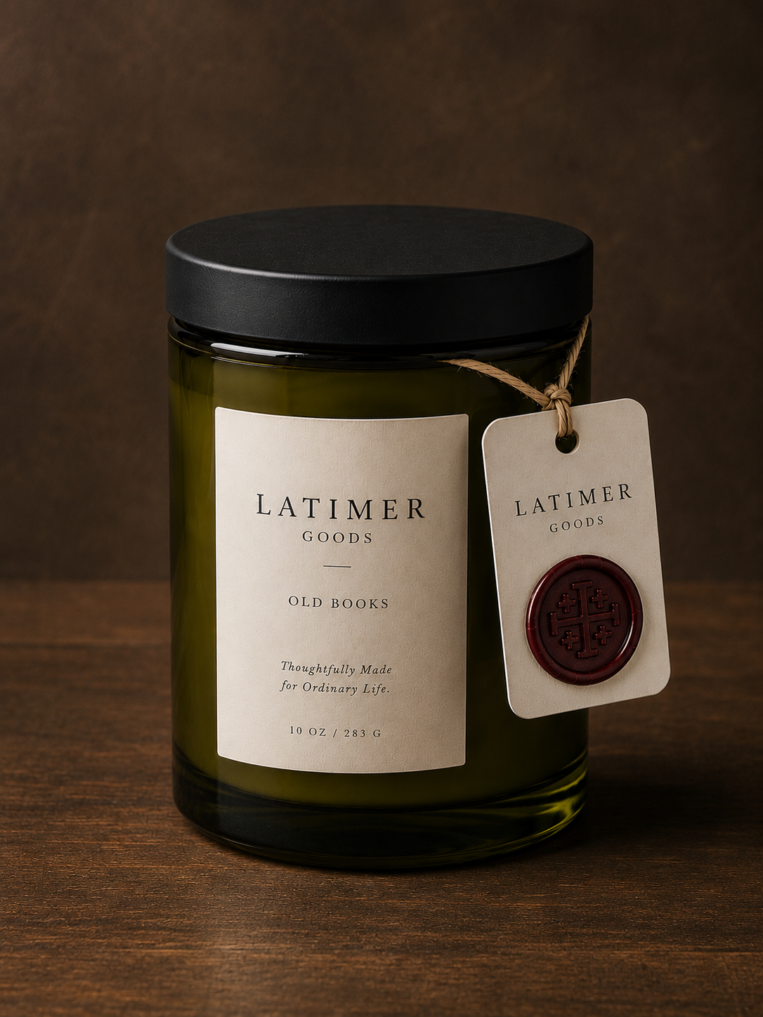 Latimer Goods Old Books Candle in olive green glass jar with ivory label and oxblood wax seal tag
